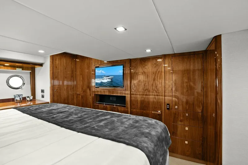 Gia Yacht Photos Pics Luxurious bedroom interior of 2021 Riviera 5400 Sport Yacht with wood paneling and TV.