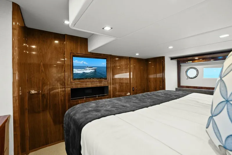 Gia Yacht Photos Pics Luxurious interior of 2021 Riviera 5400 Sport Yacht with elegant wood paneling and cozy bedding.