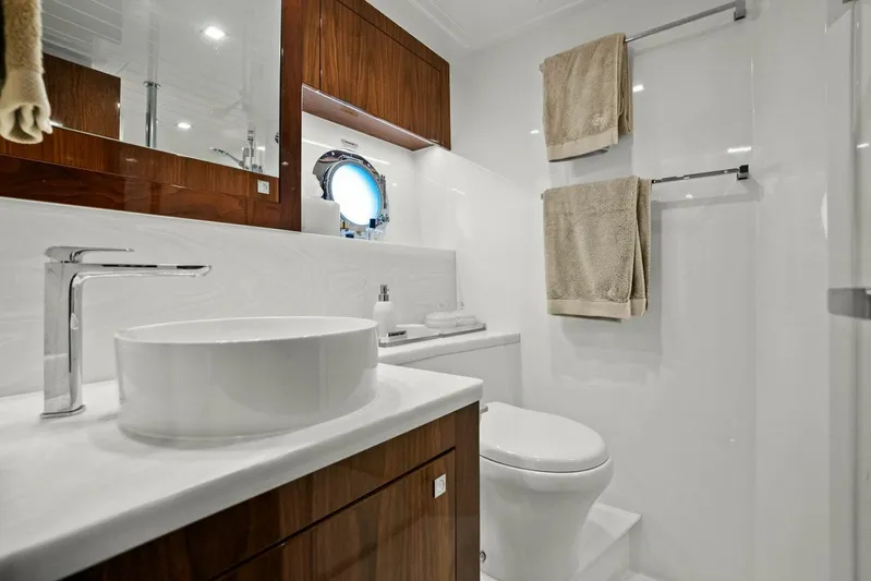 Gia Yacht Photos Pics Luxurious bathroom in 2021 Riviera 5400 Sport Yacht with modern fixtures and elegant wood accents.