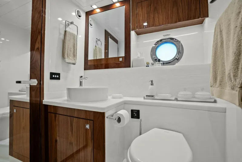 Gia Yacht Photos Pics Luxurious bathroom in 2021 Riviera 5400 Sport Yacht with modern fixtures and wood accents.