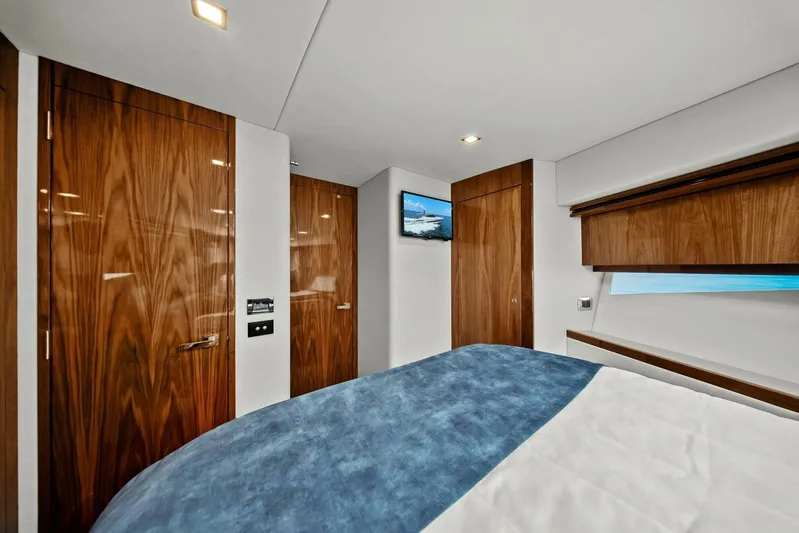 Gia Yacht Photos Pics Luxurious bedroom interior of 2021 Riviera 5400 Sport Yacht with wood accents and modern design.