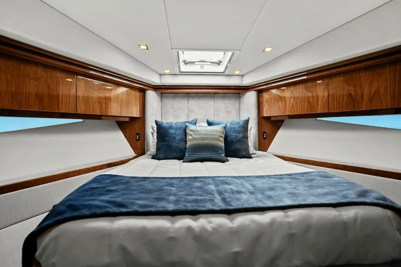 Gia Yacht Photos Pics Luxurious bedroom interior of 2021 Riviera 5400 Sport Yacht with elegant wood finishes.