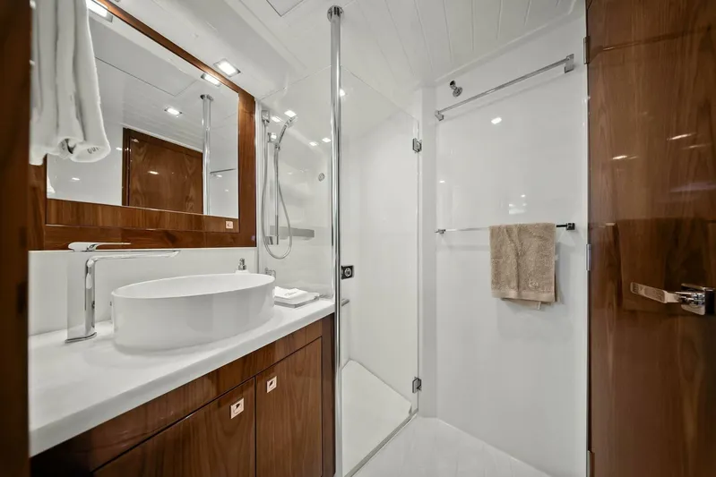 Gia Yacht Photos Pics Luxurious bathroom in 2021 Riviera 5400 Sport Yacht with modern fixtures and elegant wood accents.