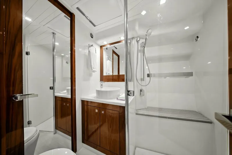 Gia Yacht Photos Pics Luxurious bathroom in 2021 Riviera 5400 Sport Yacht with modern fixtures and wooden cabinetry.