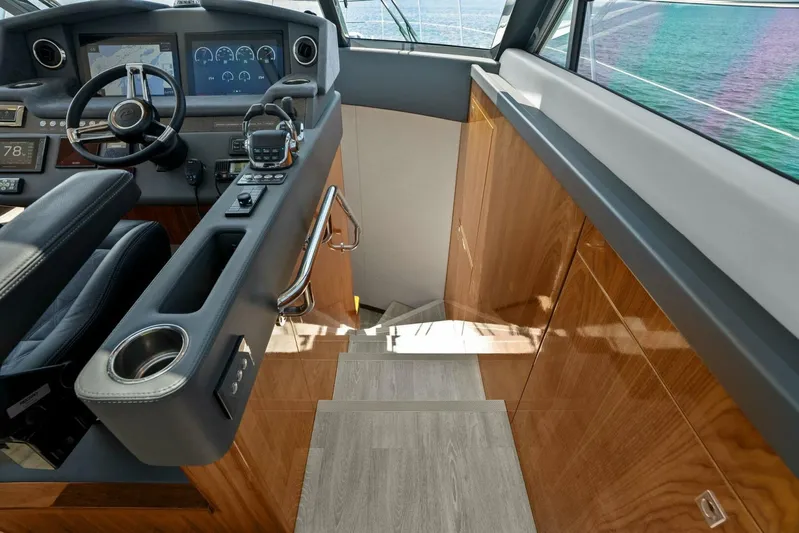 Gia Yacht Photos Pics 2021 Riviera 5400 Sport Yacht interior with sleek wood paneling and modern helm controls.