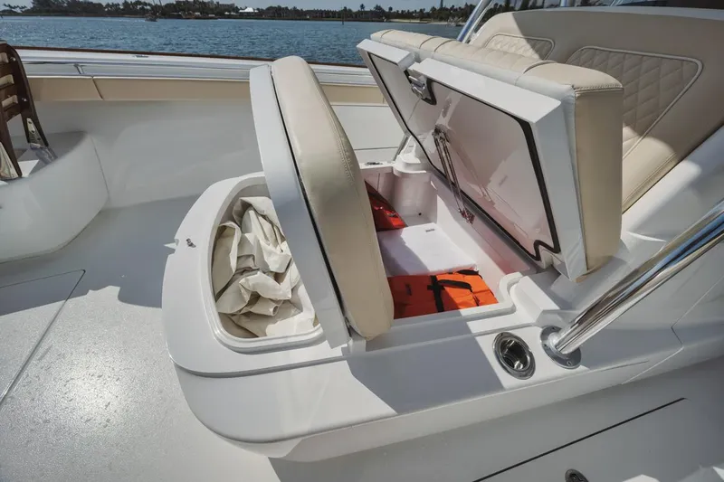 Primo Yacht Photos Pics 2023 Valhalla V-41 boat storage compartment with open seat, revealing life jackets and equipment.