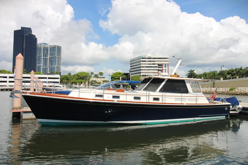 Sweet Yacht Photos Pics 2001 Grand Banks 49 Eastbay HX yacht docked in a marina with cityscape background.