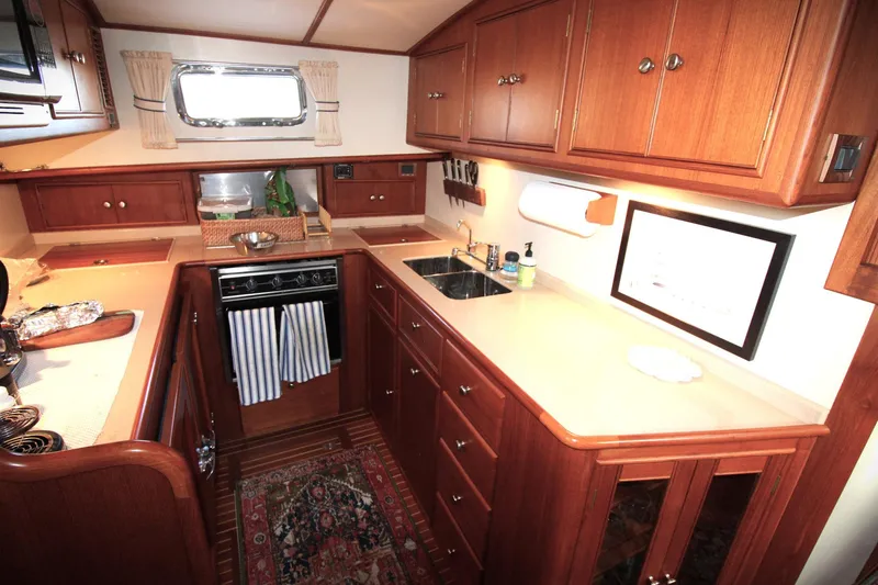 Sweet Yacht Photos Pics Luxurious 2001 Grand Banks 49 Eastbay HX yacht kitchen with wood cabinetry and modern amenities.