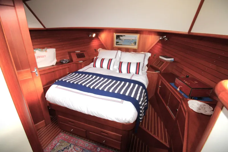 Sweet Yacht Photos Pics Luxurious cabin interior of 2001 Grand Banks 49 Eastbay HX yacht with cozy bed and wooden finish.