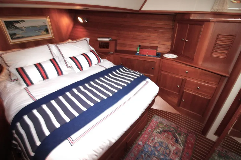 Sweet Yacht Photos Pics Luxurious cabin interior of 2001 Grand Banks 49 Eastbay HX with wood paneling and striped bedding.