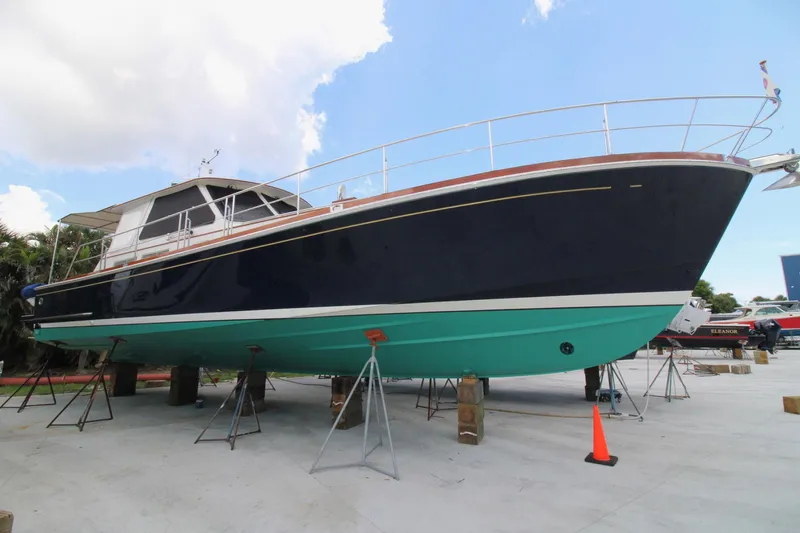 Sweet Yacht Photos Pics 2001 Grand Banks 49 Eastbay HX yacht on stands, blue hull, clear sky background.