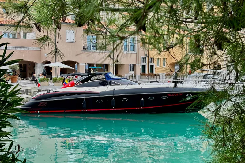  Yacht Photos Pics Luxury Sunseeker Predator 58 yacht docked in scenic marina, surrounded by lush greenery.