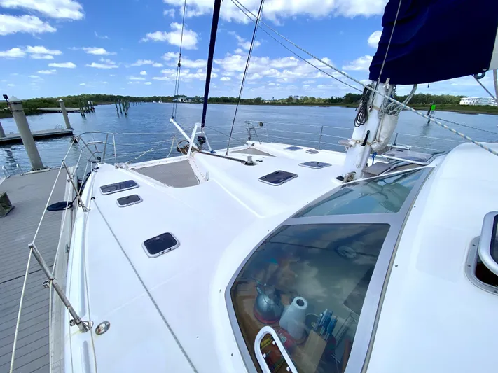 Rock N' No Roll Yacht Photos Pics Privilege 435 catamaran from 2006 docked by a serene lake under a blue sky.