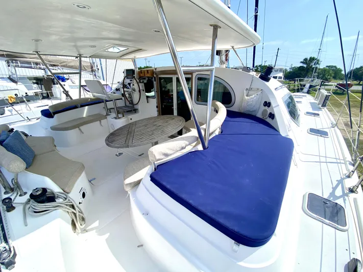 Rock N' No Roll Yacht Photos Pics Spacious deck of 2006 Privilege 435 catamaran with blue cushions and seating area.