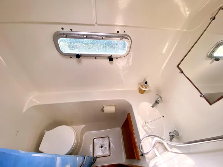 Rock N' No Roll Yacht Photos Pics Compact bathroom in 2006 Privilege 435 yacht with toilet, sink, and window.