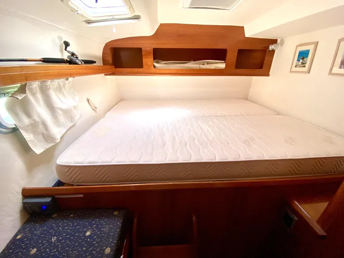 Rock N' No Roll Yacht Photos Pics Cabin interior of 2006 Privilege 435 yacht with bed and wooden storage.