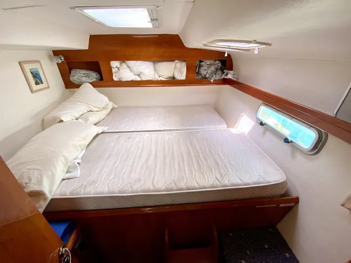 Rock N' No Roll Yacht Photos Pics Cozy cabin interior of 2006 Privilege 435 yacht with double bed and porthole.
