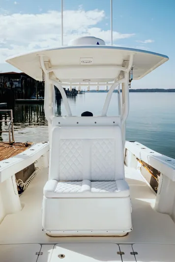  Yacht Photos Pics 2006 Yellowfin 31 CC boat with white seating, docked by calm waters.