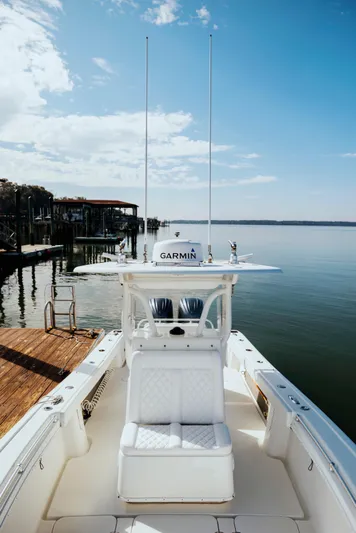  Yacht Photos Pics 2006 Yellowfin 31 CC boat docked by calm waters under a clear sky.