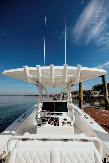  Yacht Photos Pics 2006 Yellowfin 31 CC boat with dual screens, steering wheel, and rod holders under a clear sky.
