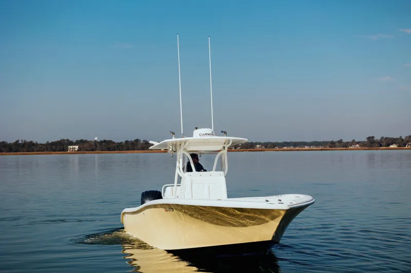  Yacht Photos Pics 2006 Yellowfin 31 CC boat cruising on calm water under clear blue sky.