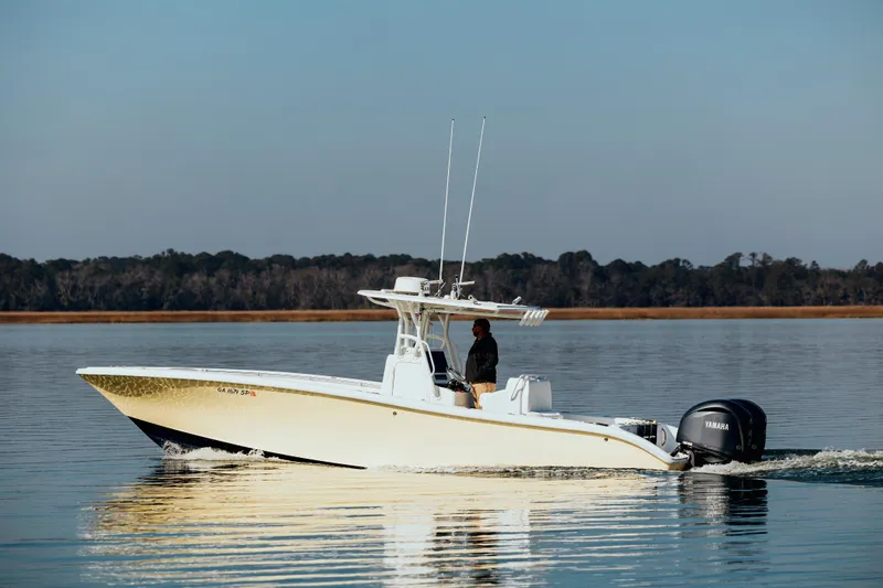  Yacht Photos Pics 2006 Yellowfin 31 CC boat cruising on calm water with Yamaha outboard engine.