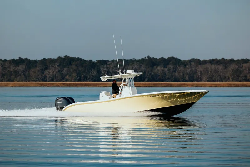  Yacht Photos Pics 2006 Yellowfin 31 CC boat cruising on calm water with forested shoreline.