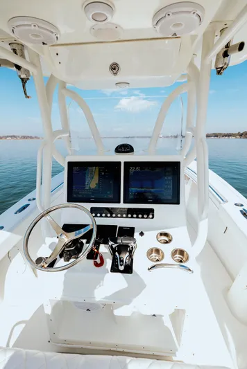  Yacht Photos Pics 2006 Yellowfin 31 CC boat helm with dual screens and steering wheel on calm water.