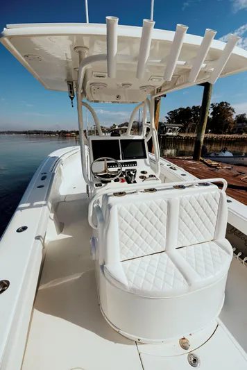  Yacht Photos Pics 2006 Yellowfin 31 CC boat with white seating and console, docked by the water.