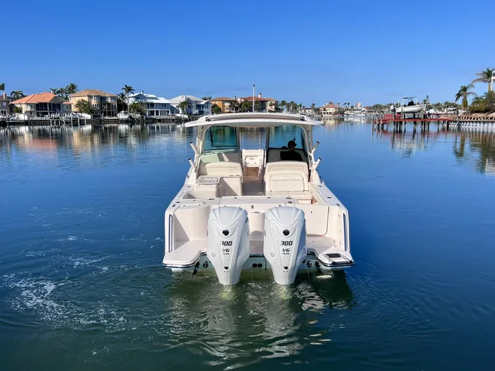  Yacht Photos Pics 2023 Grady-White Freedom 325 boat on calm water, featuring dual outboard engines.