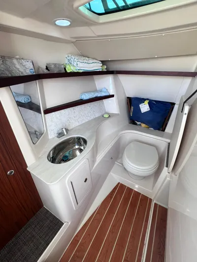  Yacht Photos Pics 2023 Grady-White Freedom 325 boat interior with sink, toilet, and storage shelves.
