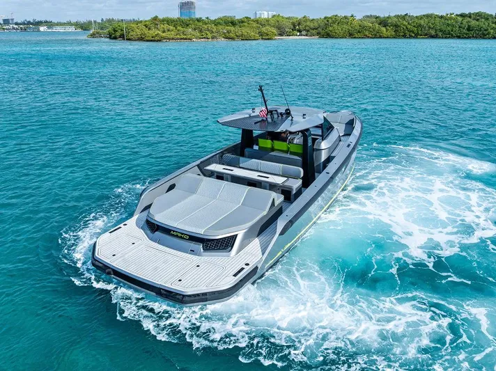 Mako Yacht Photos Pics 2024 Maori M46 yacht cruising on turquoise waters near lush green shoreline.