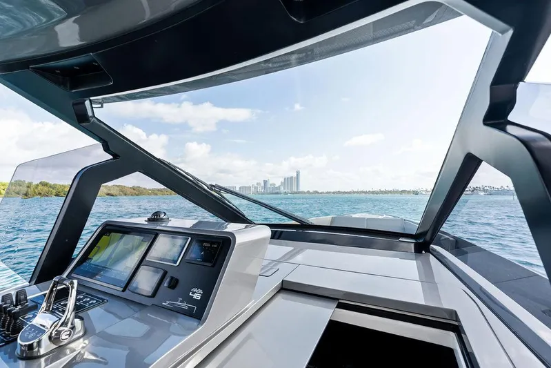 Mako Yacht Photos Pics 2024 Maori M46 yacht cockpit with modern controls, overlooking a scenic waterfront cityscape.