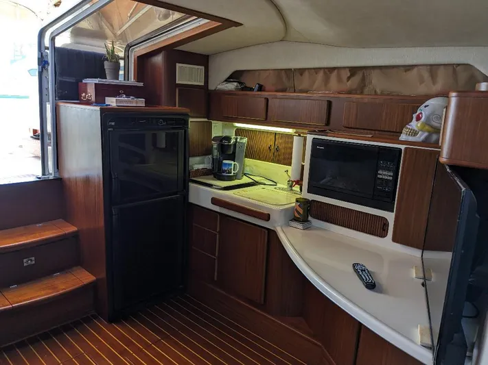 Irrational Exuberance Yacht Photos Pics Interior of 1994 Sea Ray 400 Express yacht with kitchenette, microwave, and wooden cabinetry.