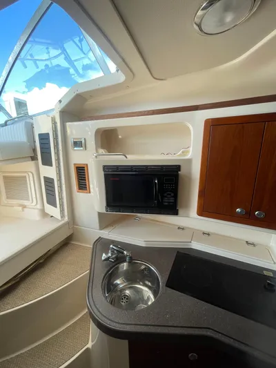 Working Girl Yacht Photos Pics 2008 Grady-White Open Express boat interior with kitchenette, microwave, and sink.