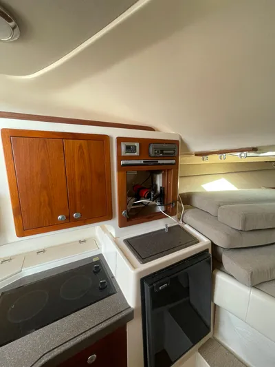 Working Girl Yacht Photos Pics 2008 Grady-White Open Express cabin interior with kitchenette and seating area.