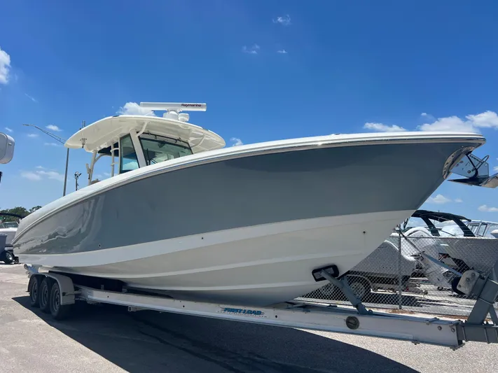  Yacht Photos Pics 2017 Boston Whaler 350 Outrage boat on trailer under clear blue sky.
