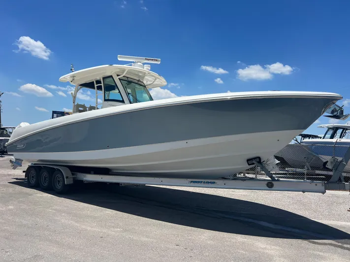  Yacht Photos Pics 2017 Boston Whaler 350 Outrage boat on trailer under clear blue sky.