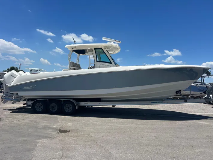  Yacht Photos Pics 2017 Boston Whaler 350 Outrage boat on trailer under clear blue sky.