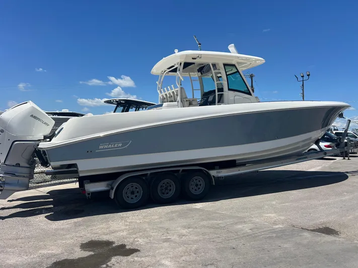  Yacht Photos Pics 2017 Boston Whaler 350 Outrage boat on trailer under clear blue sky.