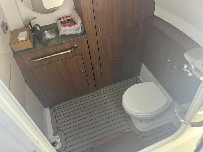  Yacht Photos Pics 2017 Boston Whaler 350 Outrage bathroom with wood cabinets, sink, and toilet.
