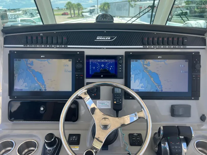  Yacht Photos Pics Control panel of a 2017 Boston Whaler 350 Outrage with navigation screens and steering wheel.