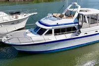 1990 Trader 41 + 2 Sundeck yacht docked on calm water.