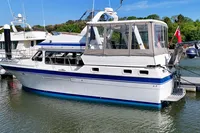 1990 Trader 41 + 2 Sundeck yacht docked in a marina, featuring a spacious cabin.