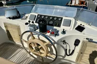 1990 Trader 41 + 2 Sundeck yacht helm with wooden wheel and navigation instruments.
