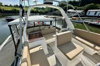 1990 Trader 41 + 2 Sundeck yacht with spacious seating, docked in a scenic marina.