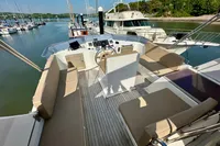 1990 Trader 41 + 2 Sundeck yacht with spacious seating and helm, docked in a marina.