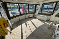 Spacious sundeck of 1990 Trader 41 + 2 Sundeck yacht with wooden flooring and marina view.