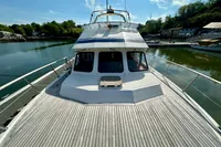 1990 Trader 41 + 2 Sundeck yacht docked, featuring spacious deck and serene waterfront view.