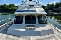 1990 Trader 41 + 2 Sundeck yacht docked, featuring spacious deck and sleek design.